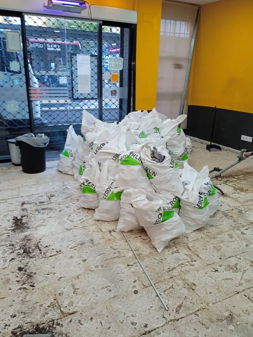 Sacos de escombro apilados en un local comercial en reforma