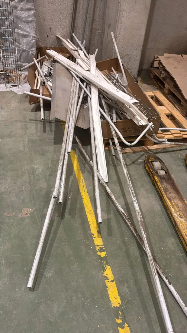 Tubos y canaletas de instalación tirados en el suelo de una nave